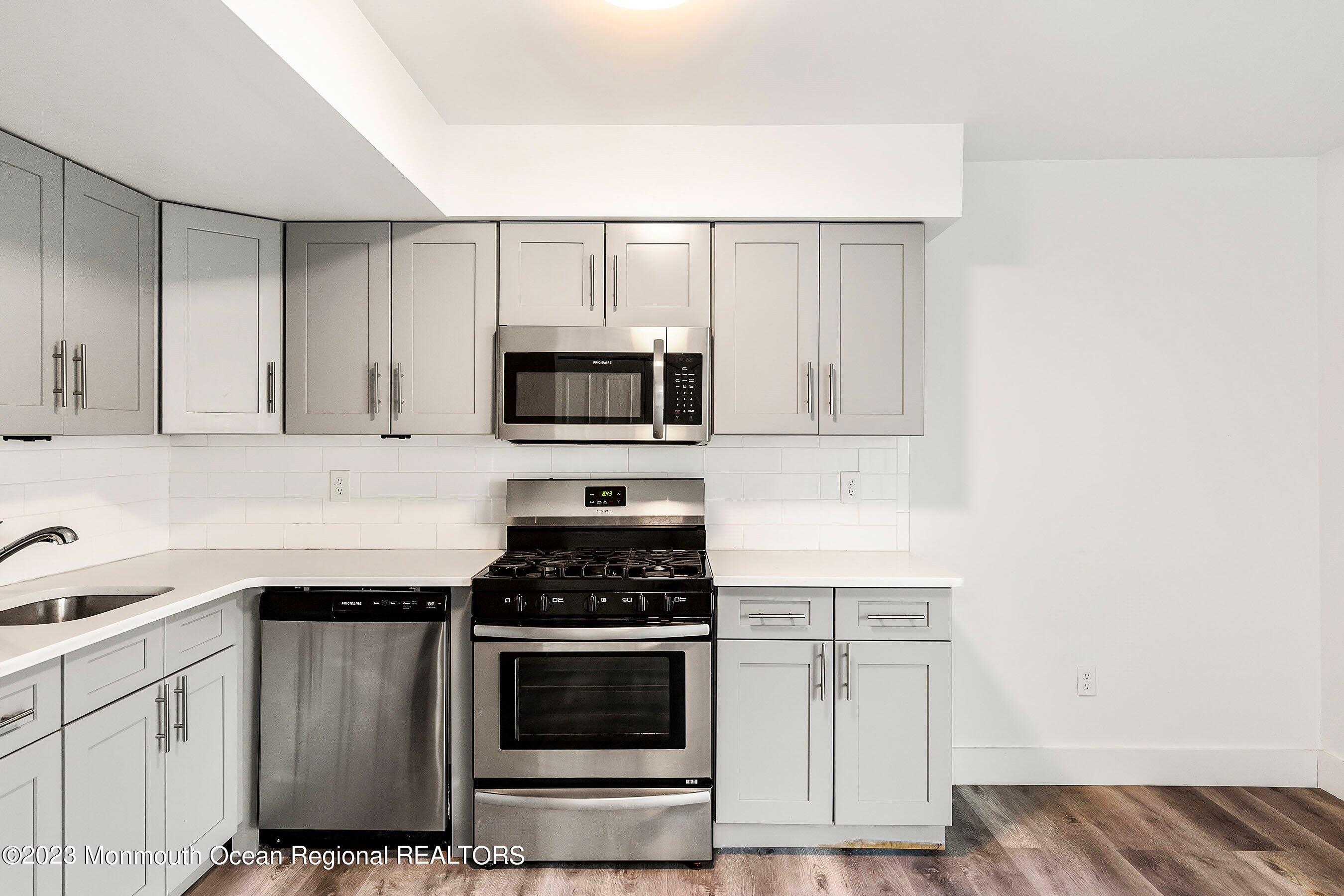 1012 Sawmill Road, Unit 6 Brick, NJ 08724 - Photo 15 of 24 a kitchen with granite countertop white cabinets and stainless steel appliances