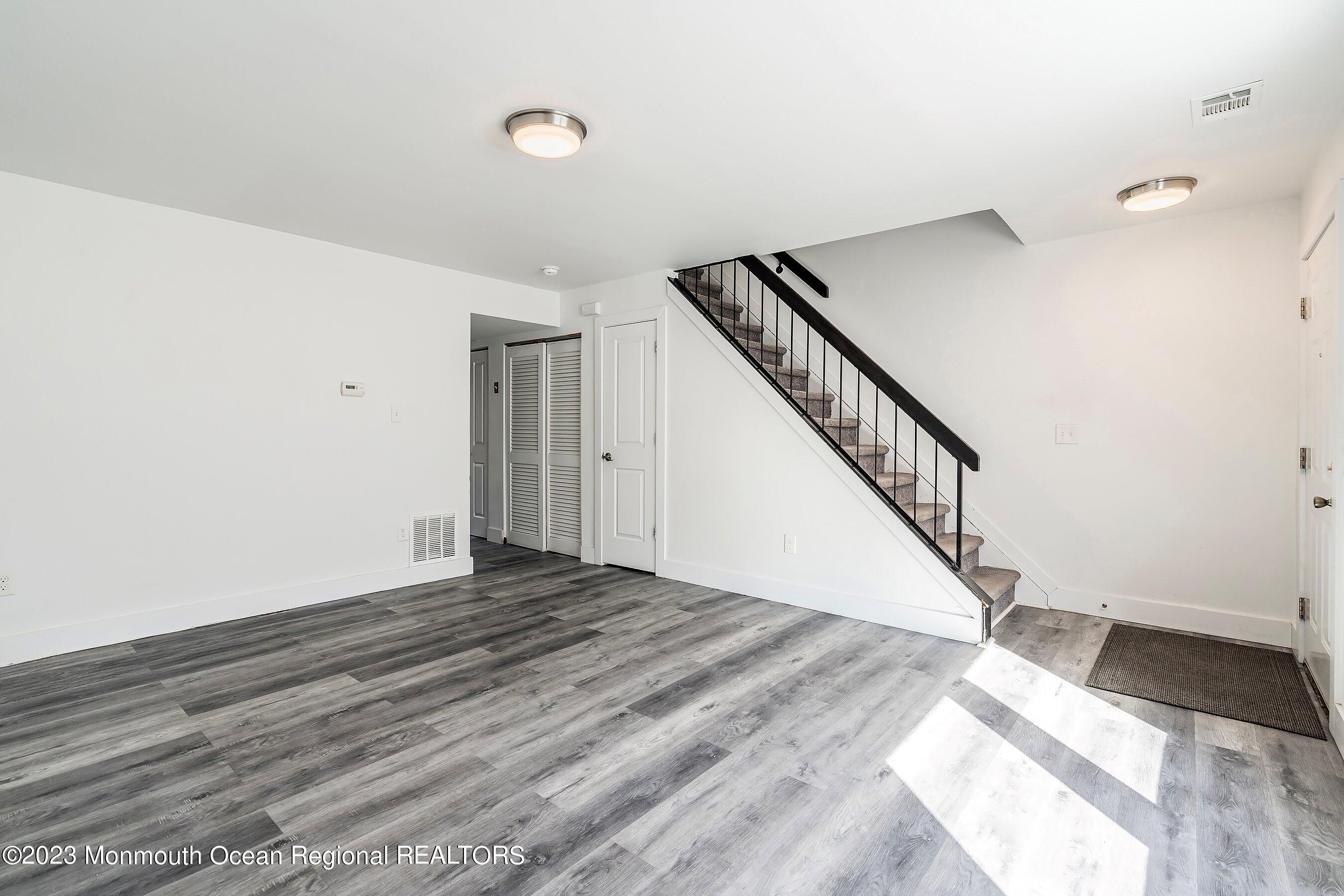 1012 Sawmill Road, Unit 6 Brick, NJ 08724 - Photo 6 of 24 a view of an empty room with wooden floor and stairs