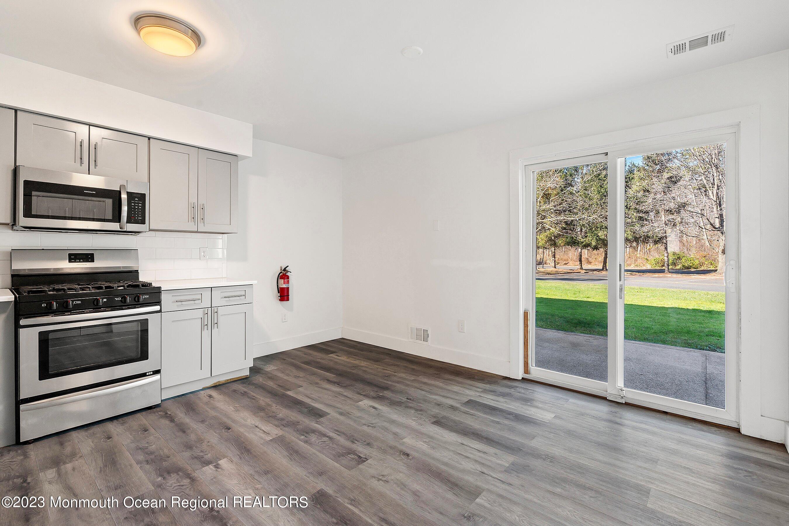 1012 Sawmill Road, Unit 6 Brick, NJ 08724 - Photo 8 of 24 a kitchen with granite countertop a stove and a wooden floor