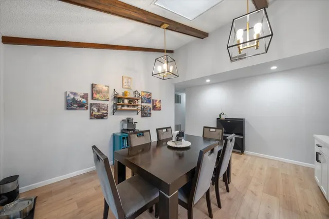 a view of a dining room with furniture and a chandelier fan