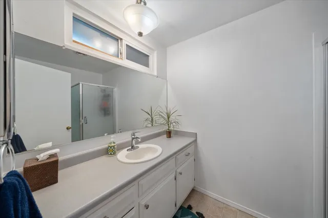 a bathroom with a sink vanity granite and a mirror
