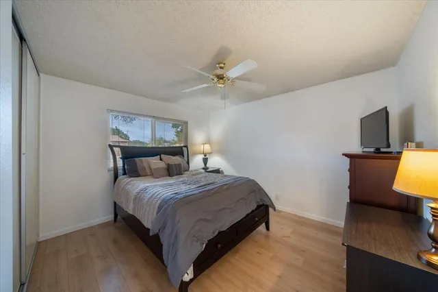 a bedroom with a bed window table and chair