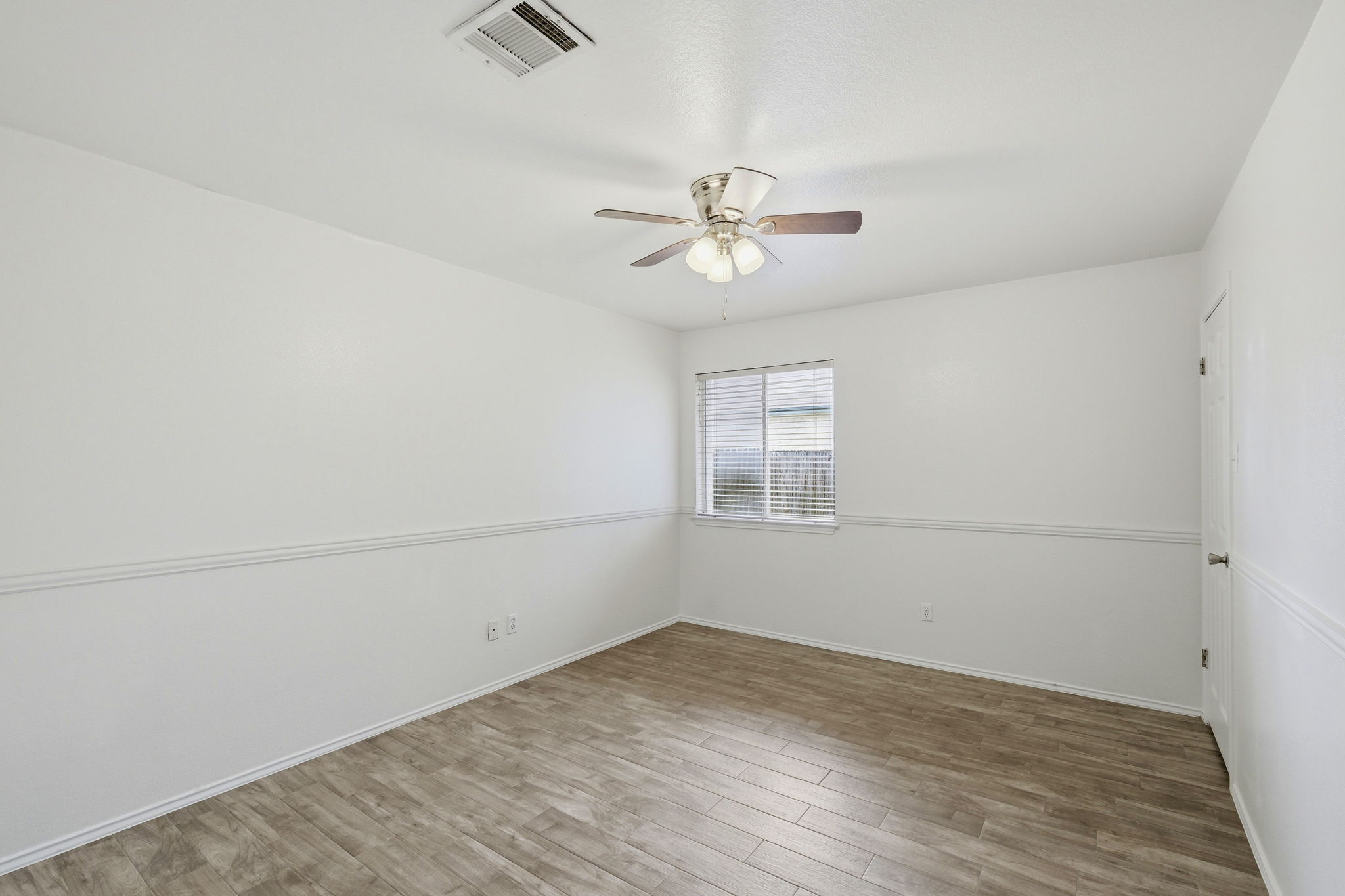 1005 Rolling Ridge Drive Round Rock, TX 78665 - Photo 10 of 18 A quiet bedroom with light wood-look flooring and a window offering natural light.