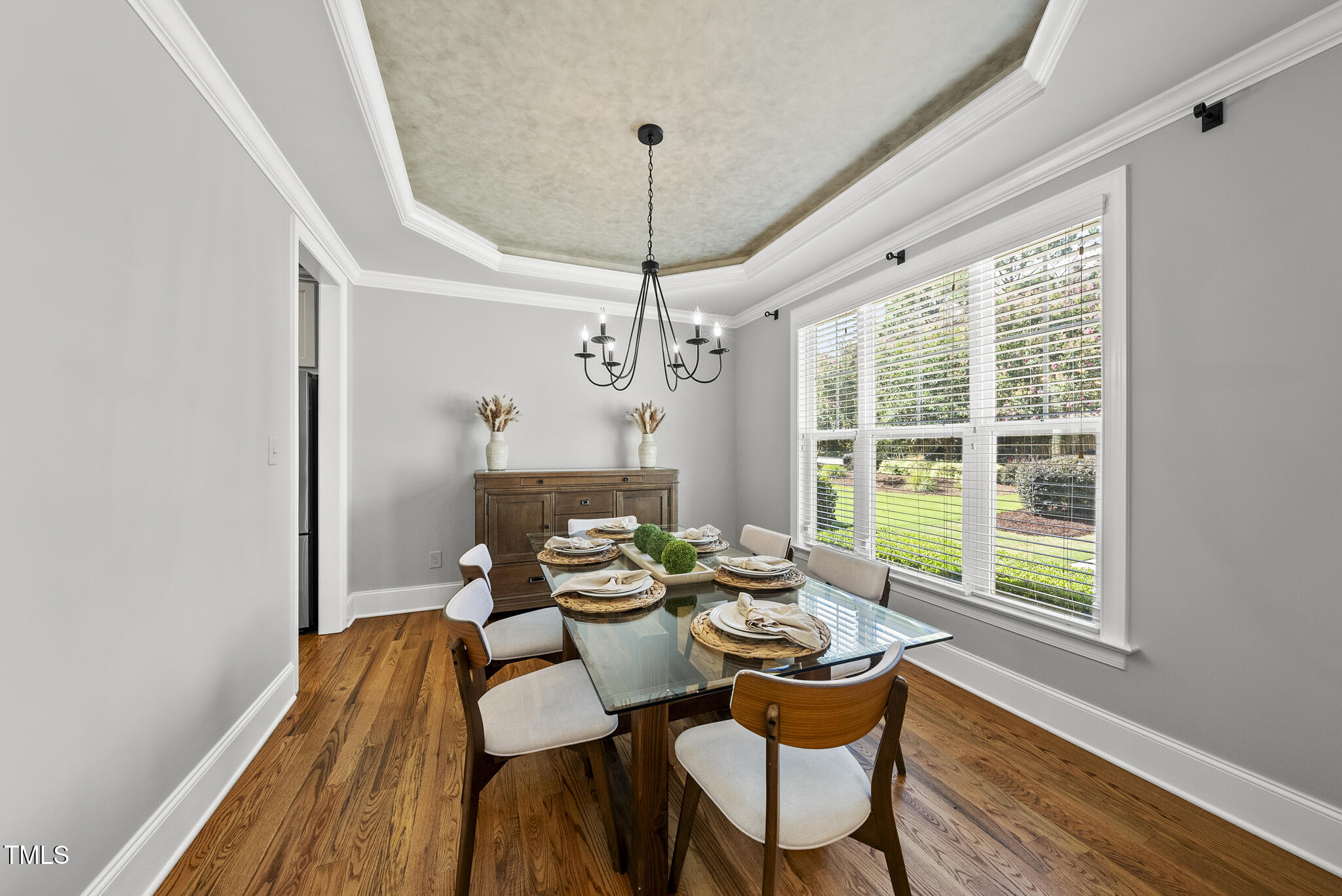 2216 Gresham Lake Road Raleigh, NC 27615 - Photo 18 of 52 a dining room with furniture a chandelier and wooden floor