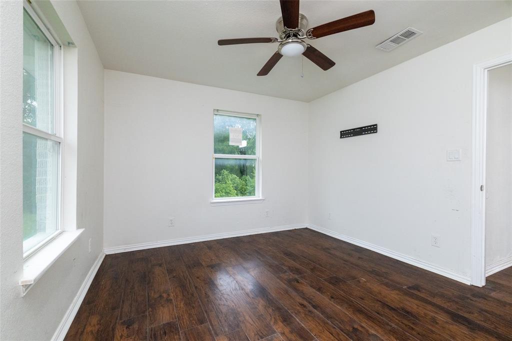 805 East Belt Line Road DeSoto, TX 75115 - Photo 9 of 15 an empty room with wooden floor fan and windows