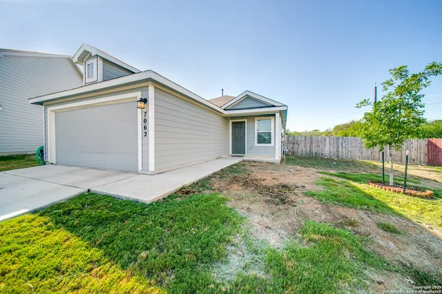 a view of backyard of house with wooden fence