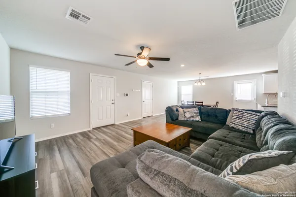 a living room with furniture and a ceiling fan