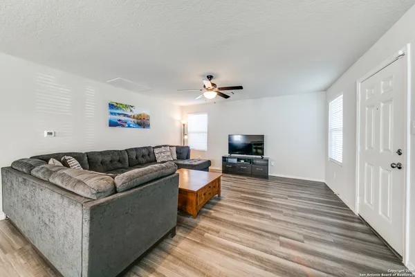 a living room with furniture and a wooden floor