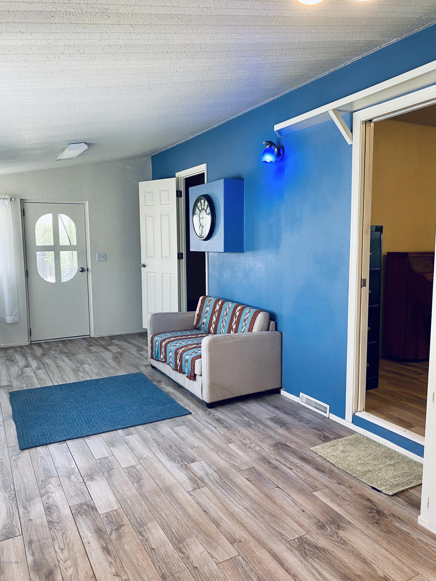 15433 West Telegraph Road, Unit 4 Santa Paula, CA 93060 - Photo 31 of 52 a bedroom with a bed and dresser with wooden floor