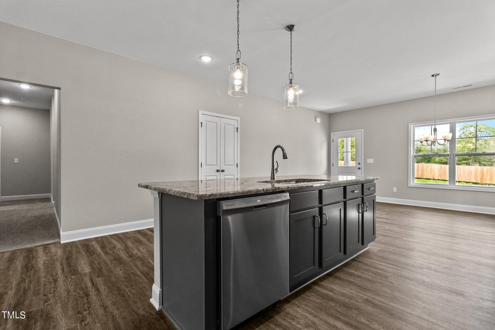 111 Regis Lane Coats, NC 27521 - Photo 12 of 36 a kitchen with stainless steel appliances granite countertop a sink a window and wooden floor