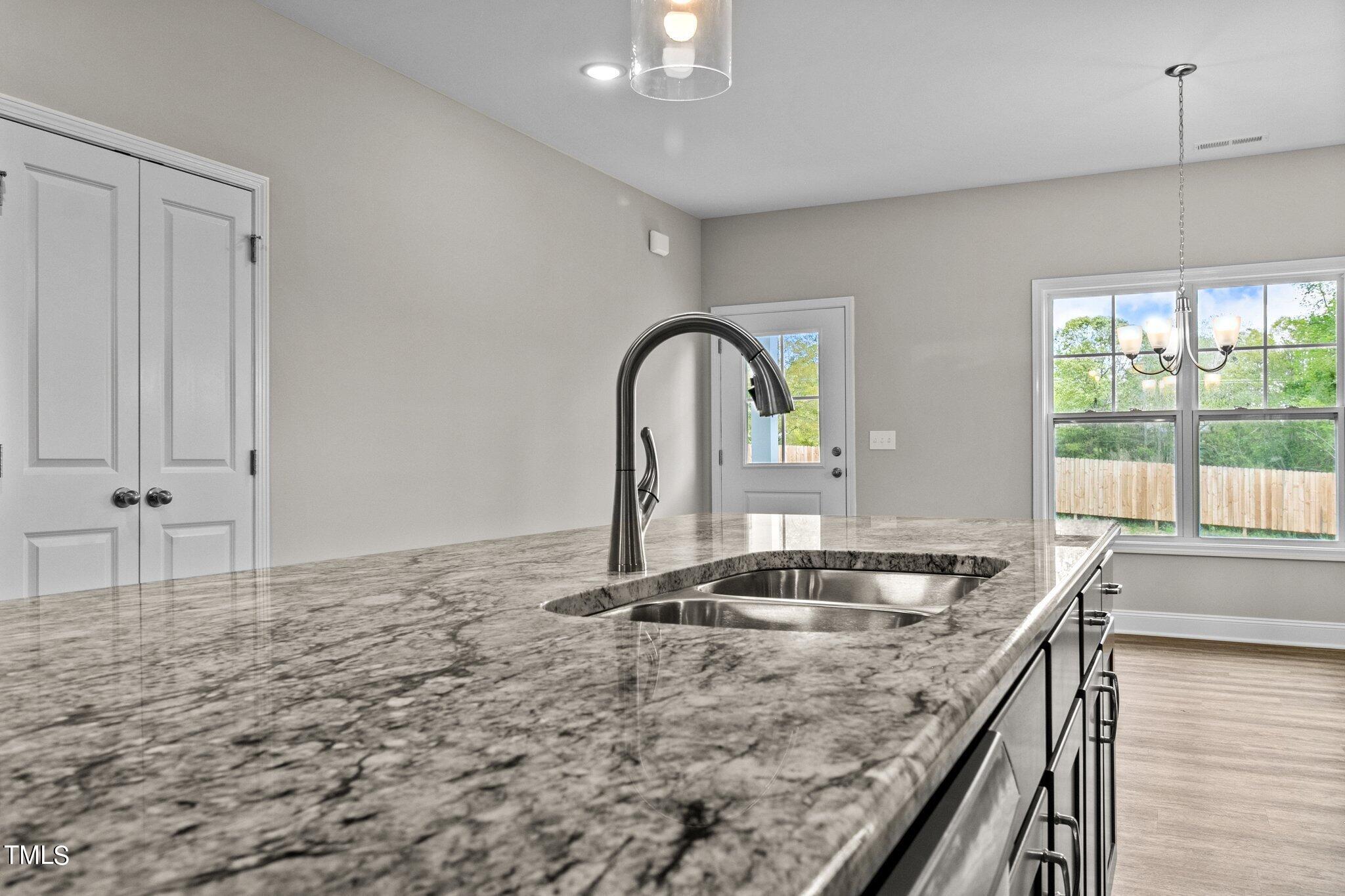 111 Regis Lane Coats, NC 27521 - Photo 13 of 36 a kitchen with granite countertop a stove and a sink