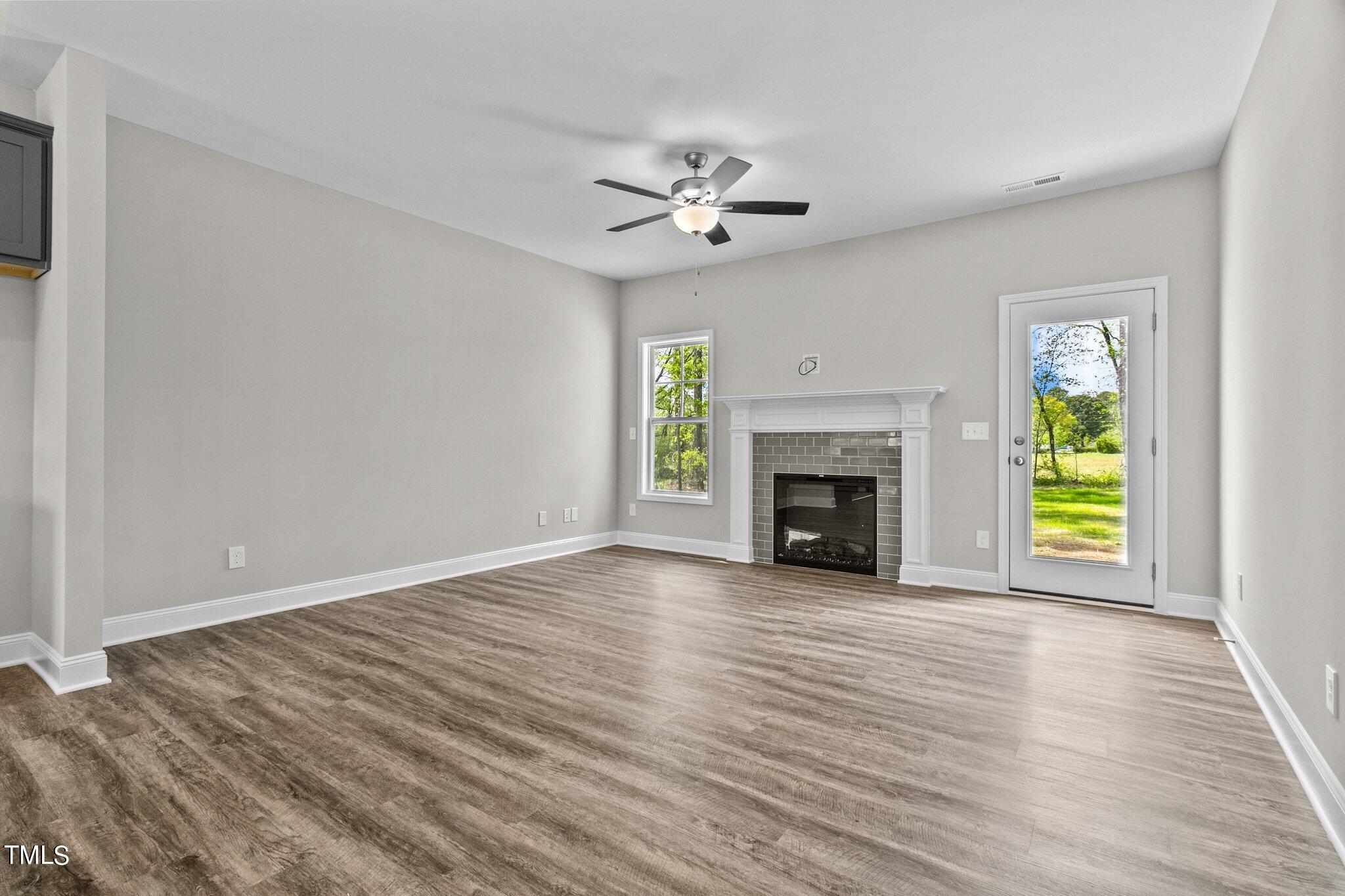 111 Regis Lane Coats, NC 27521 - Photo 4 of 36 wooden floor fireplace and windows in an empty room