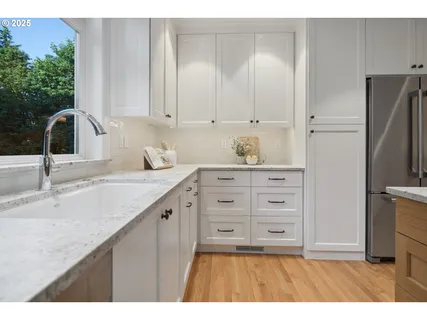 a kitchen with granite countertop a sink and a refrigerator