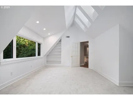 a view of an empty room with wooden floor and windows