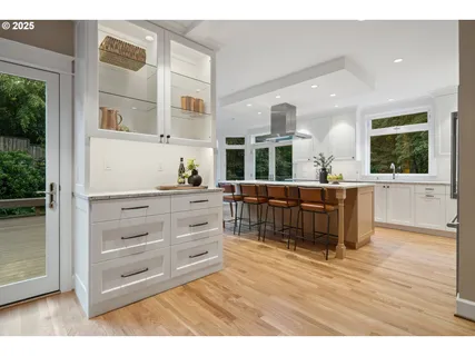a living room with furniture cabinets and wooden floor