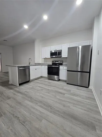 a kitchen with a refrigerator and a stove top oven