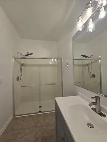 a bathroom with a sink shower and a mirror