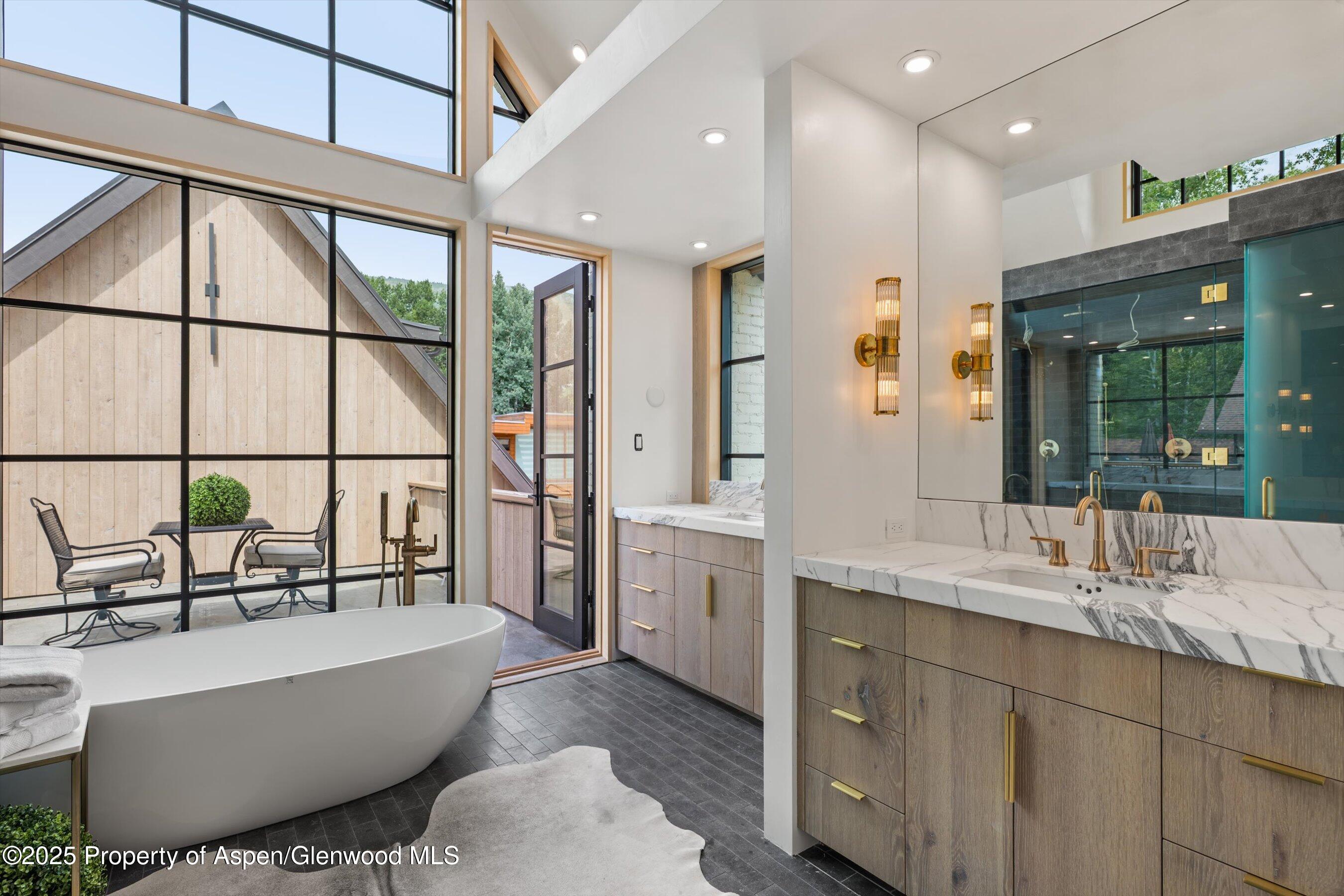 502 North 6th Street Aspen, CO 81611 - Photo 14 of 17 a spacious bathroom with a double vanity sink a bathtub and next to a window