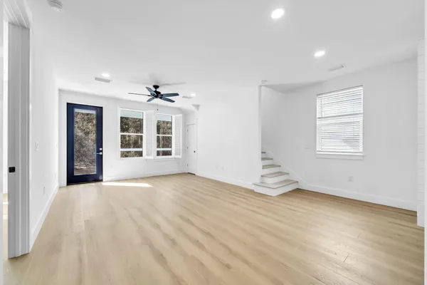 a view of a livingroom with wooden floor and a ceiling fan