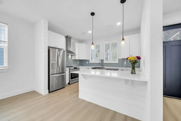 a kitchen with kitchen island white cabinets and stainless steel appliances