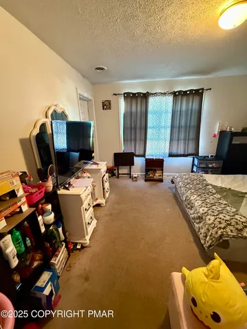 a bedroom with furniture and a flat screen tv