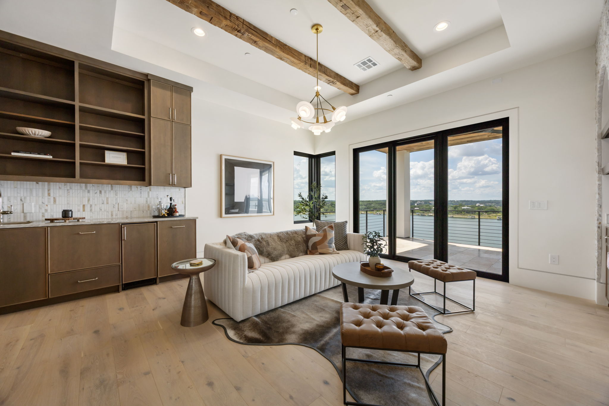1496 Buffalo Gap Road Lakeway, TX 78734 - Photo 17 of 37 A refined living area boasts exposed wood beams and broad sliding doors opening to expansive water views.