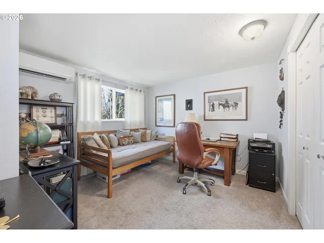 a view of a workspace with furniture and a window