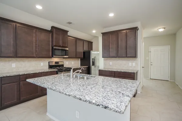 a kitchen with a sink stove and refrigerator