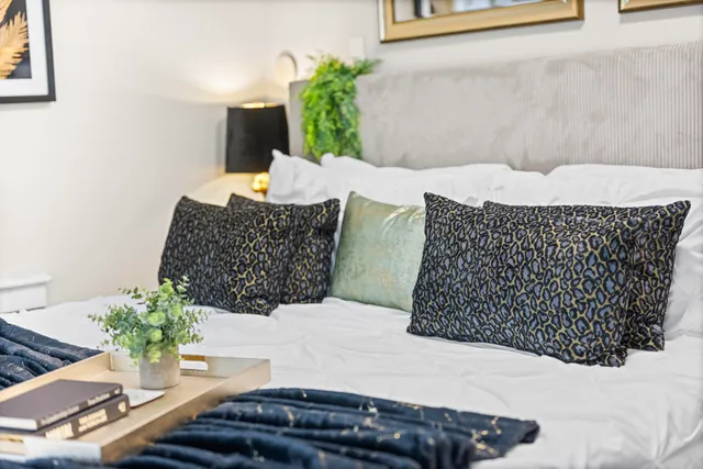a large white bed sitting in a bedroom next to a window