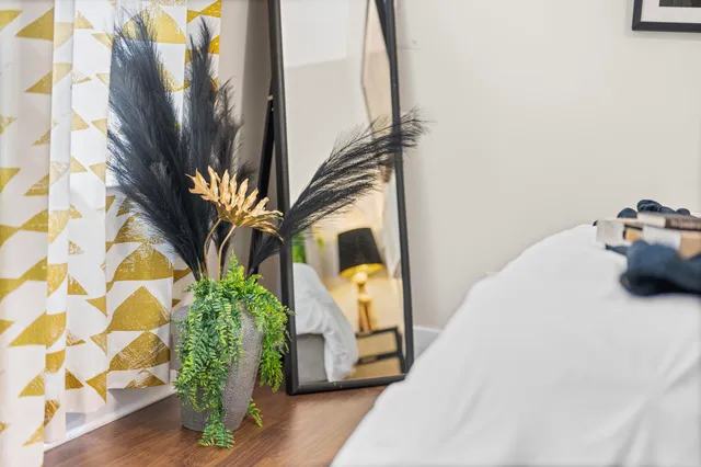 a bed sitting in a bedroom with a white comforter