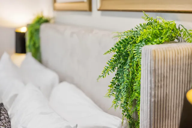 a bedroom with a bed and dresser with wooden floor