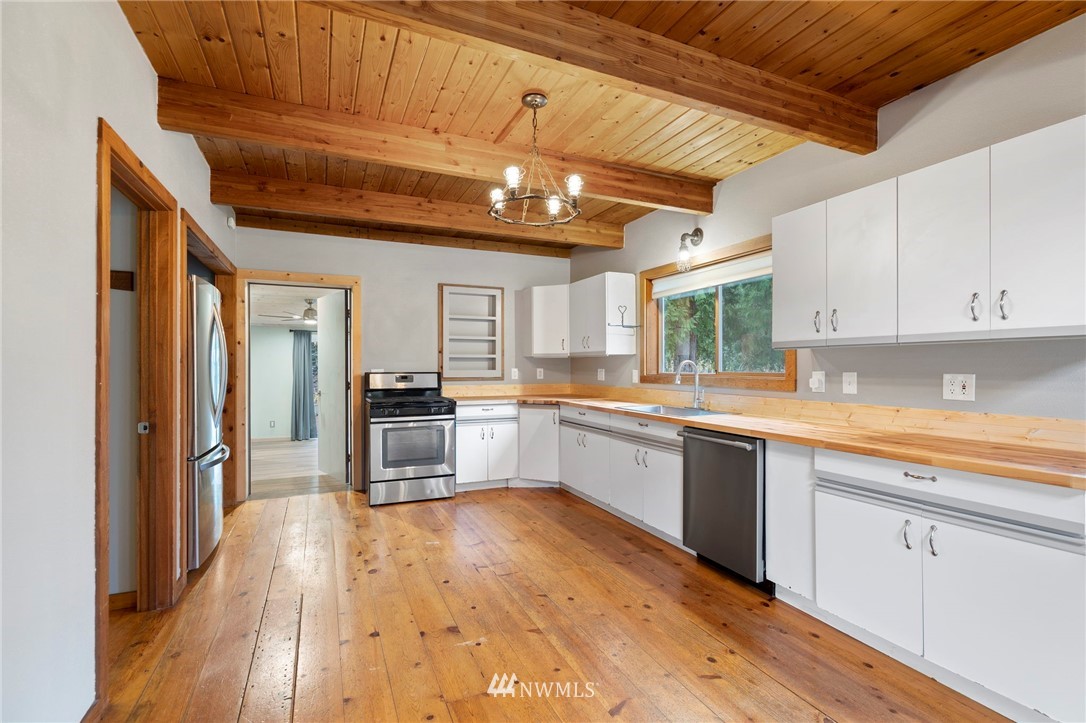 15542 Runyon Road Southeast Rainier, WA 98576 - Photo 6 of 23 a large kitchen with cabinets wooden floor and stainless steel appliances