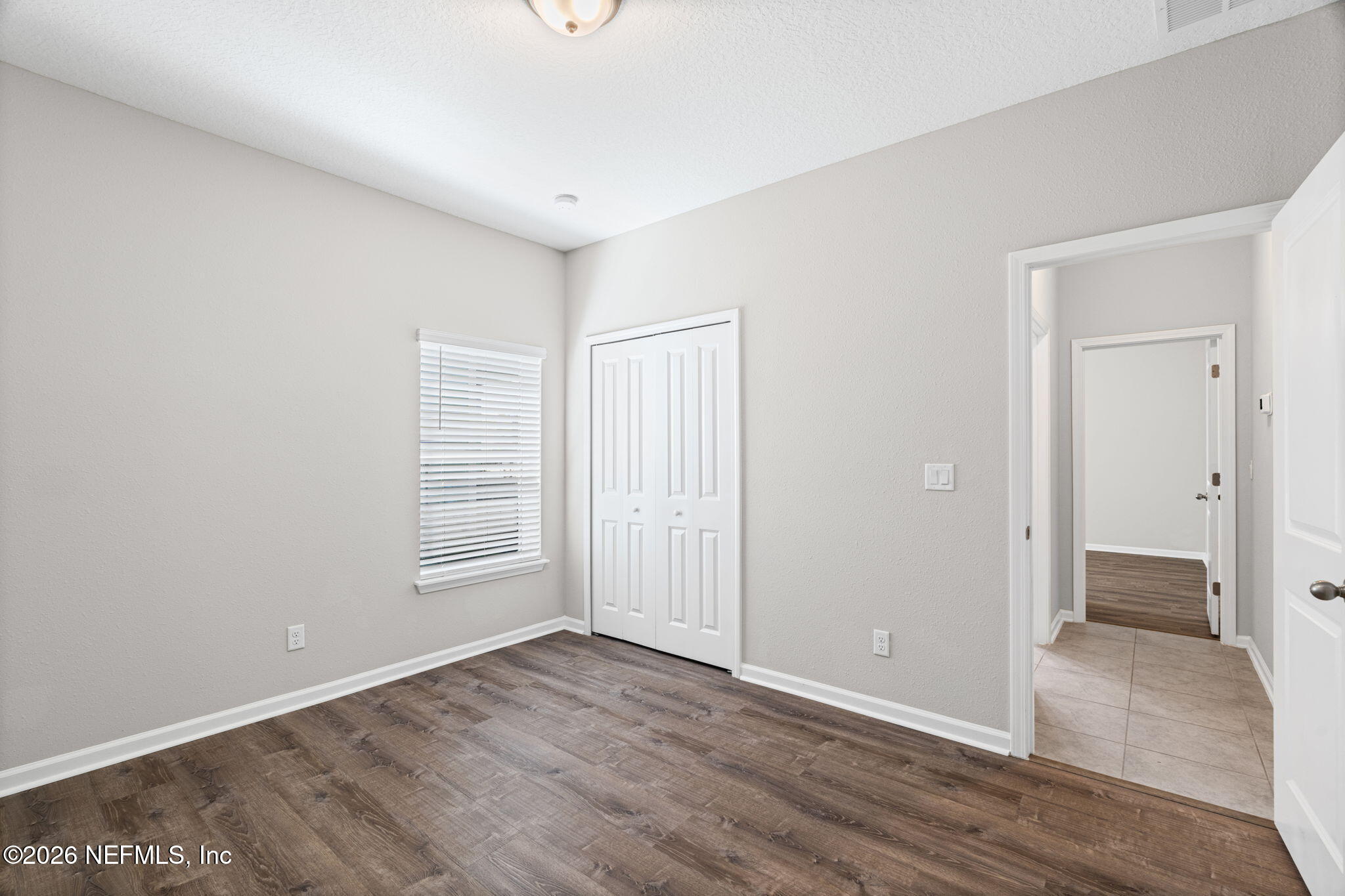 75209 Chelsea Gdn Way Yulee, FL 32097 - Photo 17 of 33 an empty room with wooden floor and windows