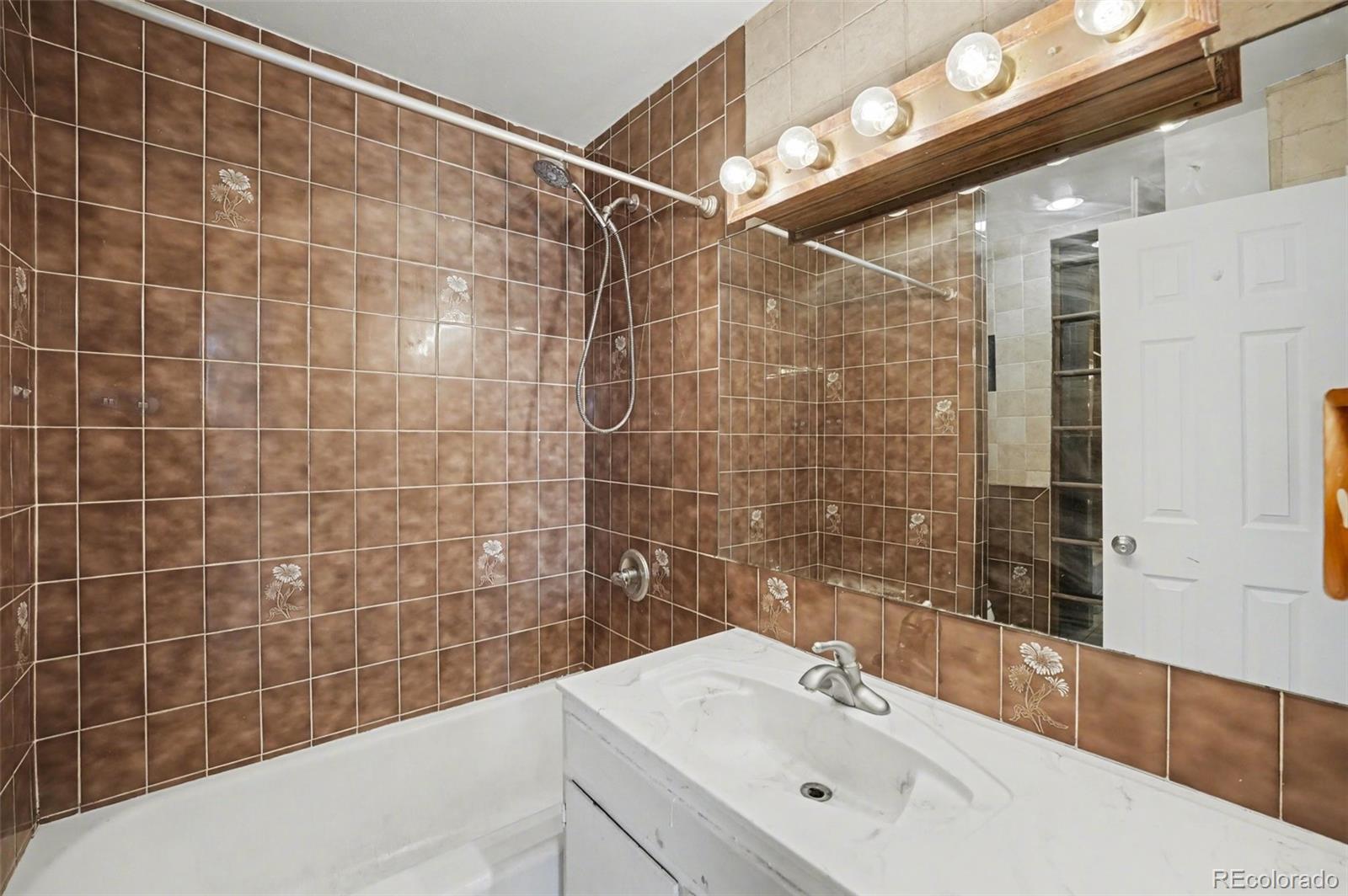 1701 Ironton Street Aurora, CO 80010 - Photo 12 of 23 a bathroom with a sink mirror and shower