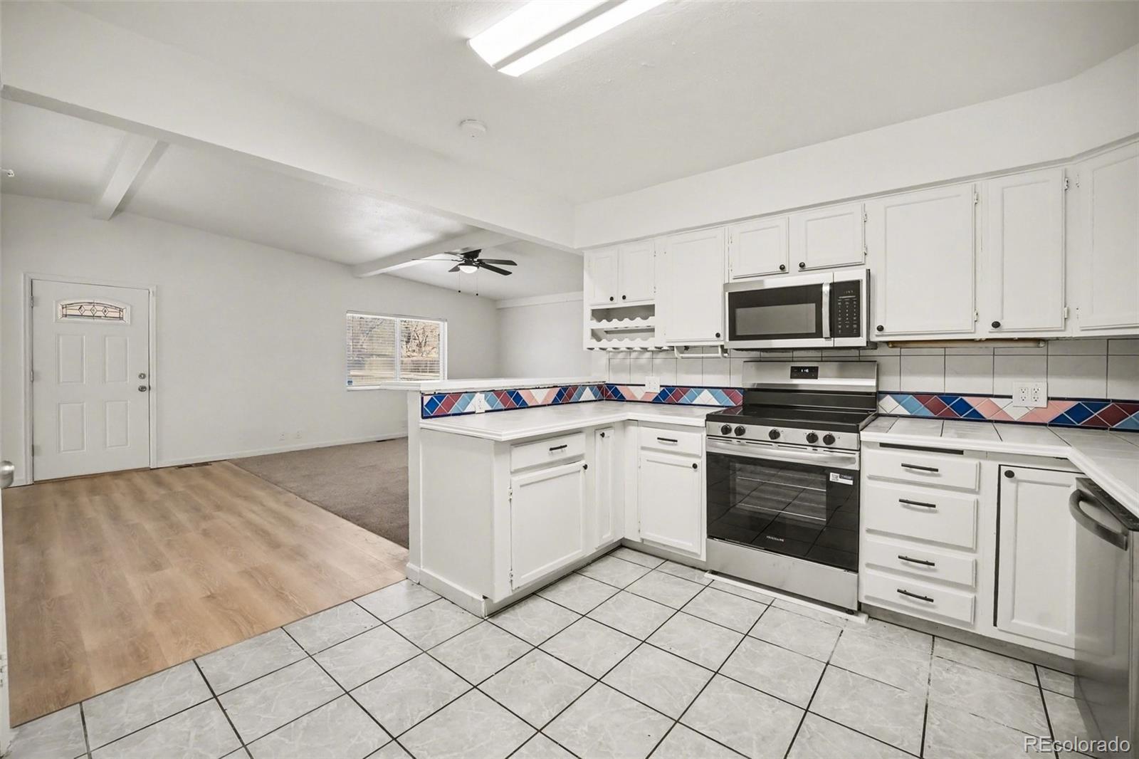 1701 Ironton Street Aurora, CO 80010 - Photo 7 of 23 a kitchen with white cabinets stainless steel appliances and sink