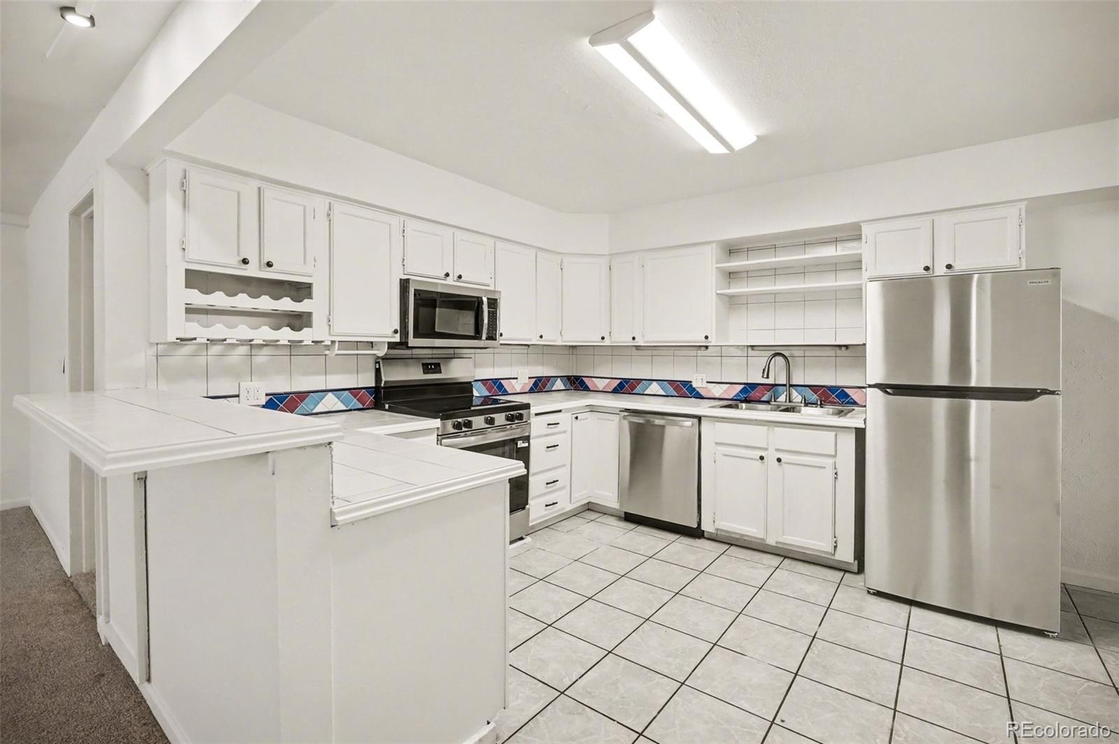 1701 Ironton Street Aurora, CO 80010 - Photo 8 of 23 a kitchen with cabinets stainless steel appliances and a window