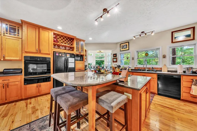 a kitchen with stainless steel appliances granite countertop a refrigerator and a stove top oven