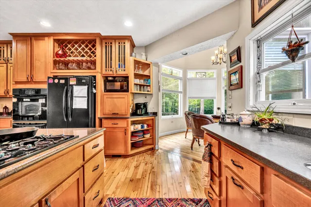 a living room with stainless steel appliances kitchen island granite countertop furniture and a rug