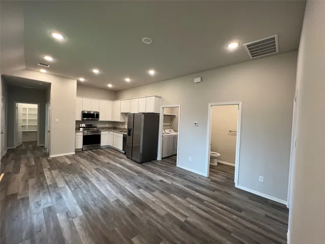 a view of kitchen with refrigerator microwave and stove top oven