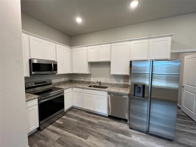 a kitchen with stainless steel appliances granite countertop a stove and a refrigerator
