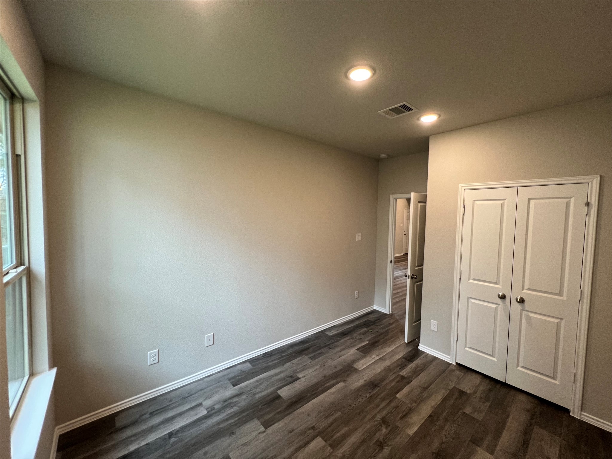 11595 Persimmon Street Willis, TX 77318 - Photo 10 of 14 an empty room with wooden floor and windows