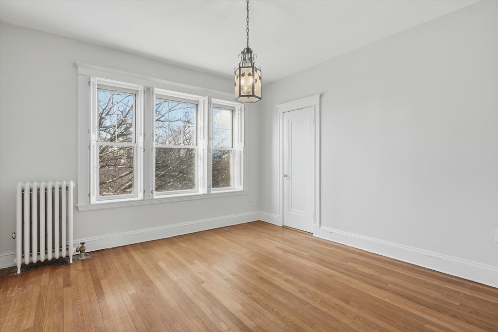 70 Fenway, Unit 51 Boston, MA 02115 - Photo 19 of 24 a view of an empty room with wooden floor and a window