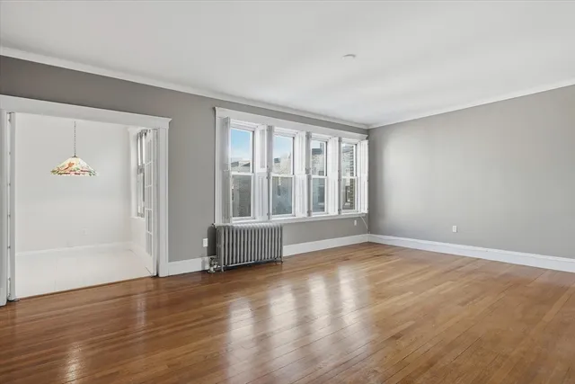 a view of an empty room with wooden floor