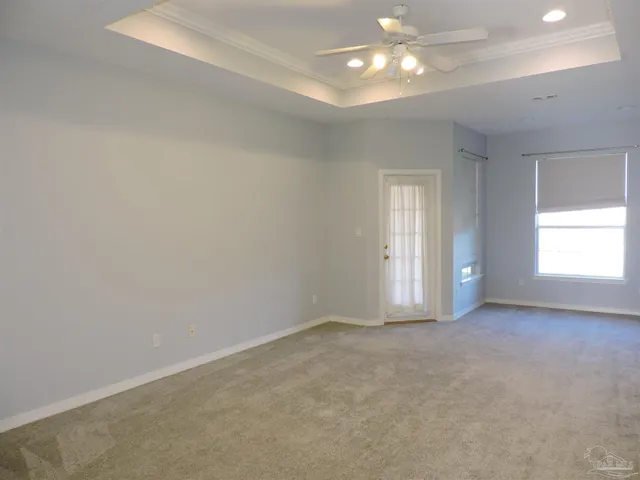 en empty room with windows and chandelier fan