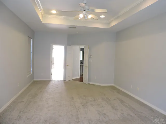 a view of an empty room with a chandelier fan