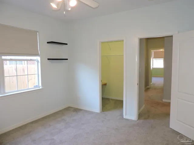 an empty room with windows and closet