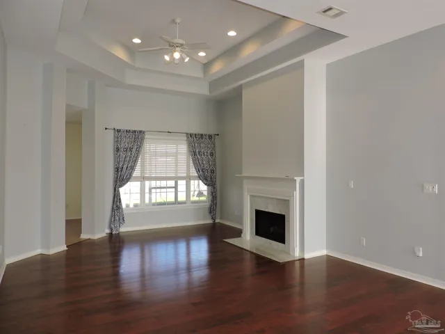 an empty room with wooden floor and fireplace