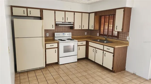 a kitchen with a stove sink and cabinets