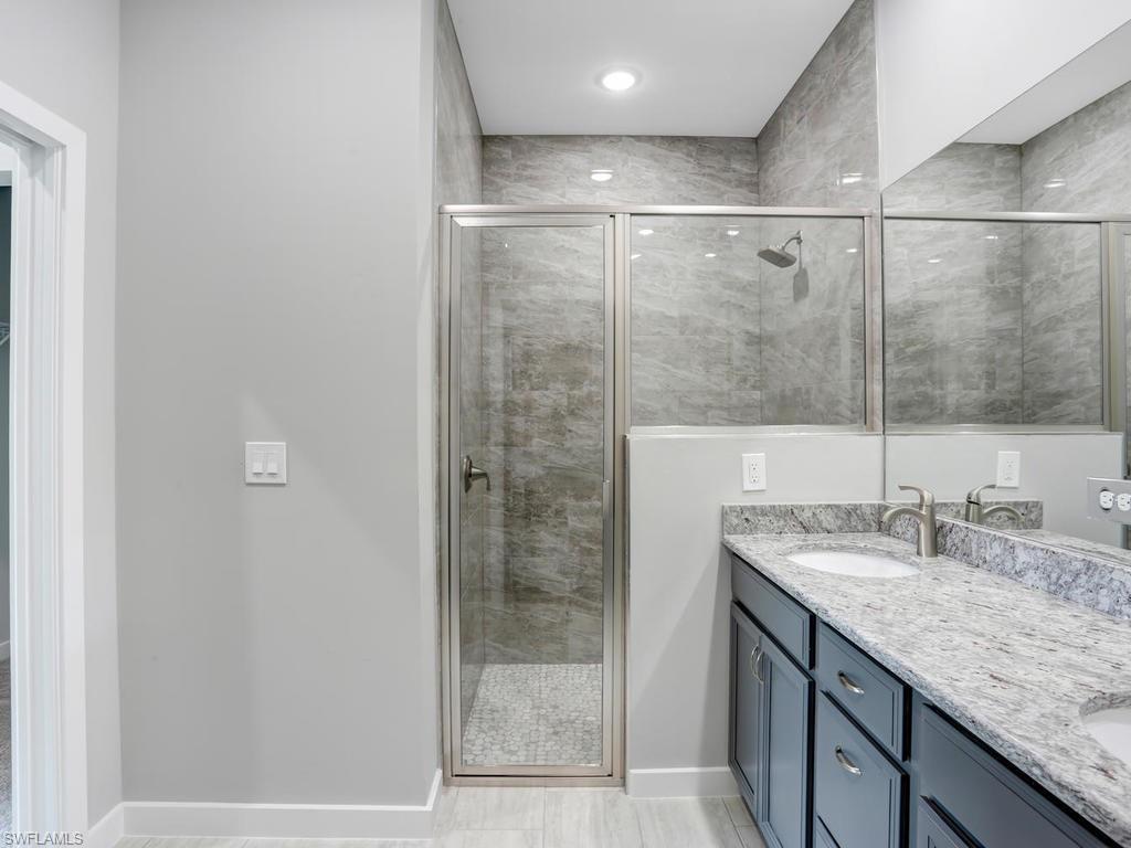 17385 Connecticut Road Fort Myers, FL 33967 - Photo 27 of 31 a bathroom with a granite countertop bathtub shower sink and mirror