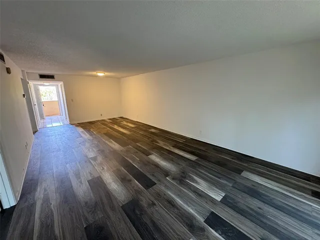 a view of an empty room and wooden floor